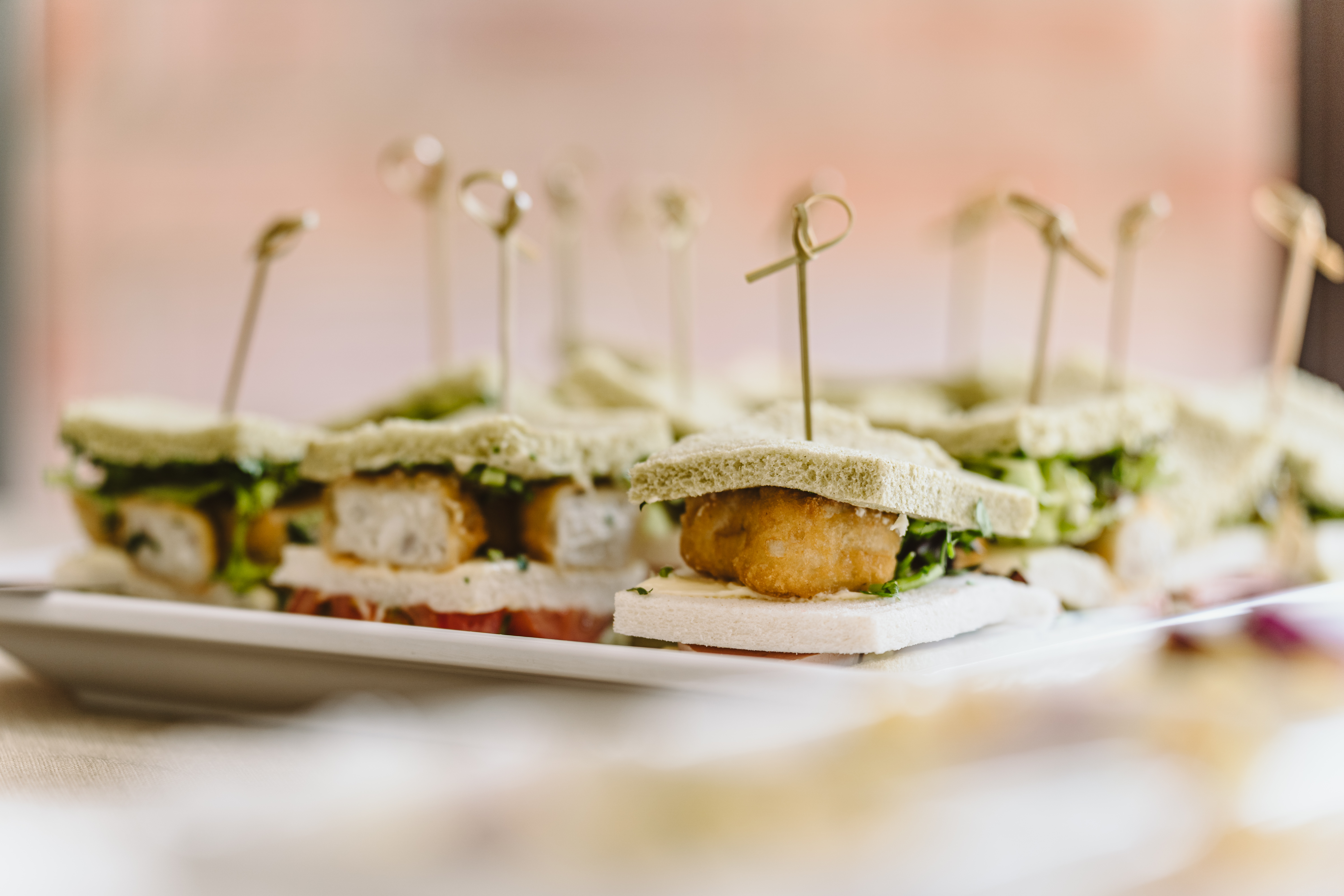 Mundgerechte Sandwiches mit Spießen, belegt mit frischem Gemüse und Hähnchen.