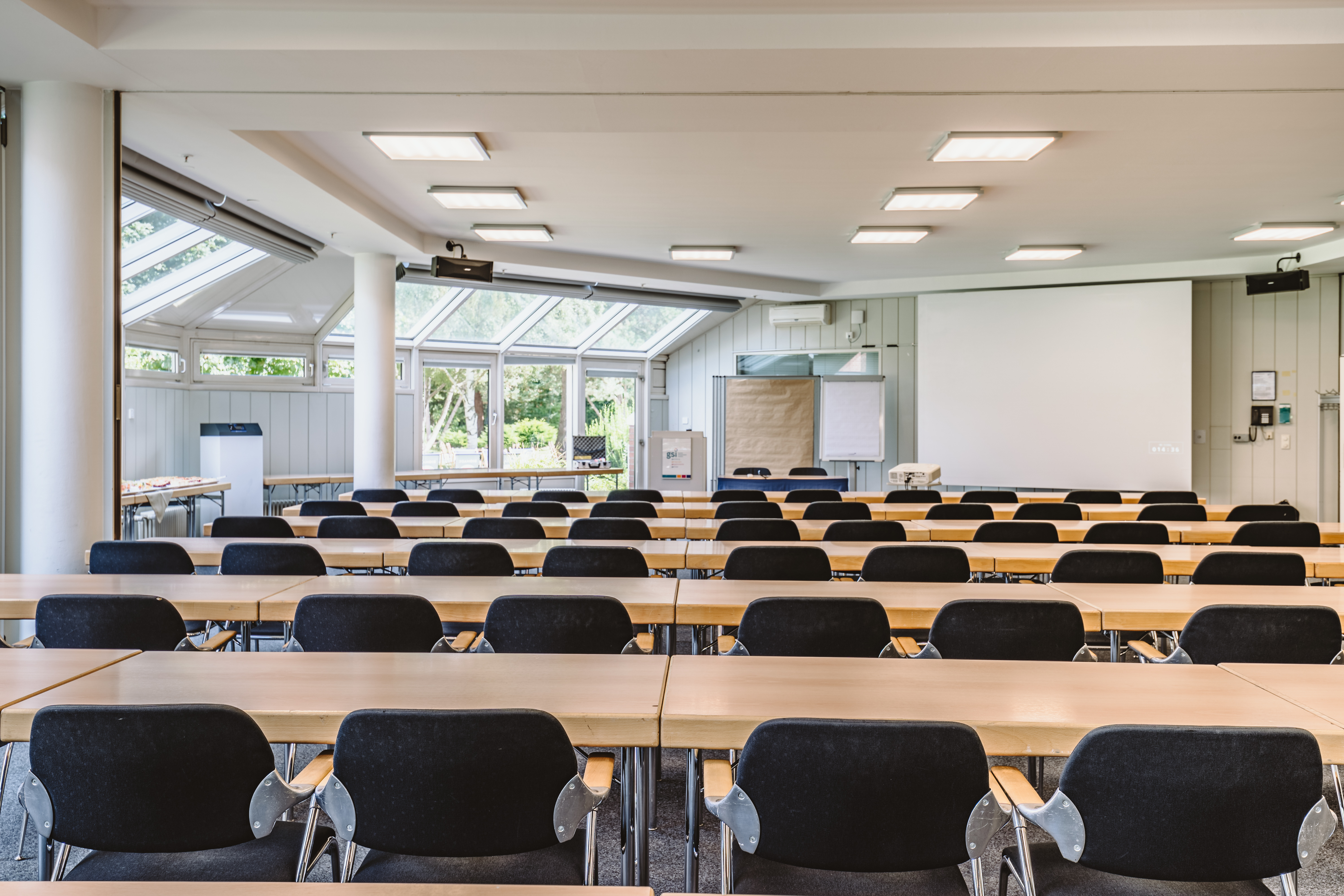 Veranstaltungsraum in Parlament-Bestuhlung mit Podium, Leinwand und Pinnwand