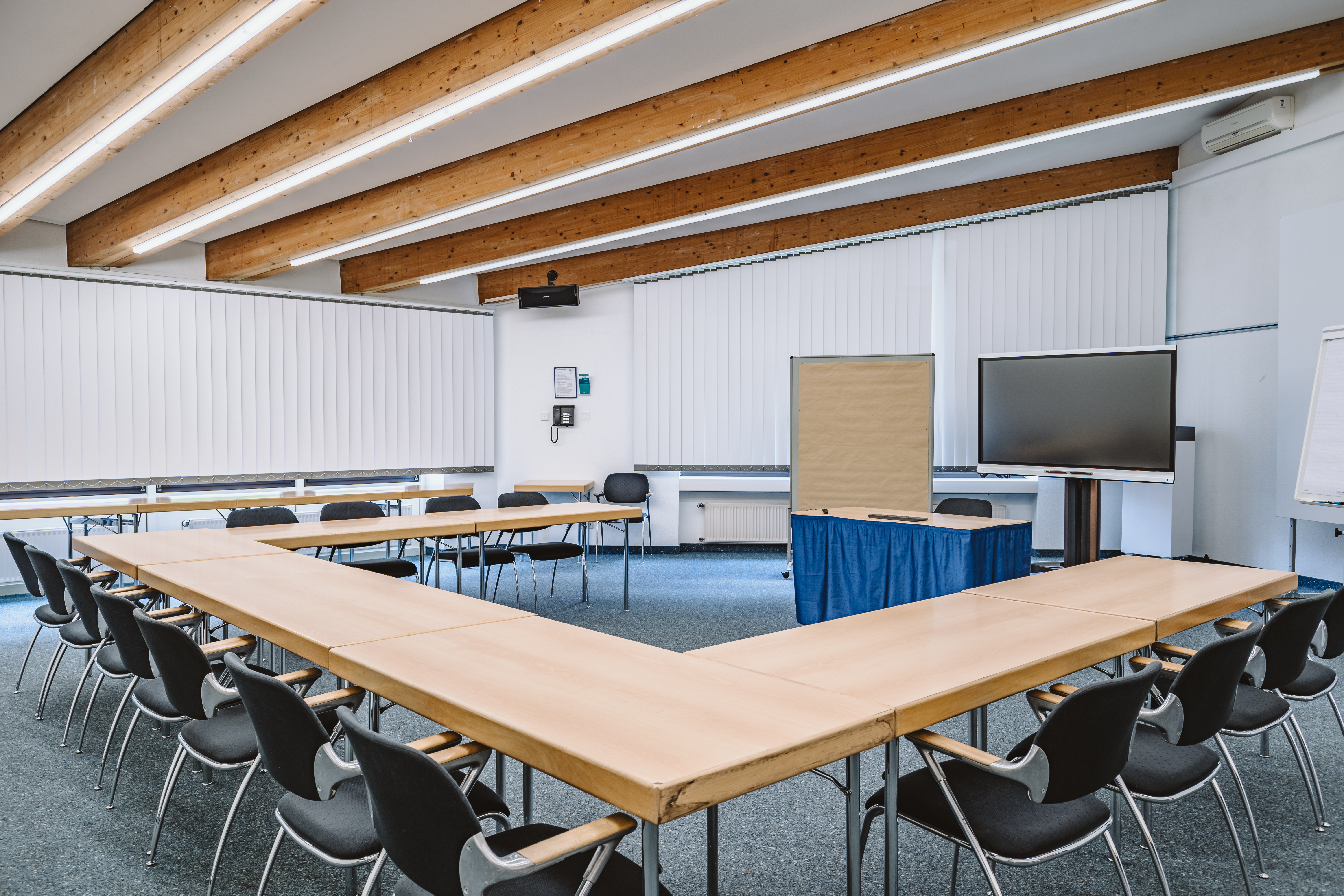 Tagungsraum mit U-Form-Bestuhlung, Smartboard und Pinnwand